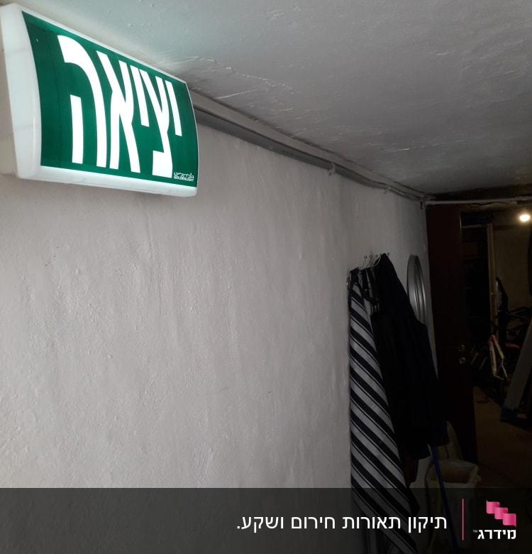 שלט יציאה מואר על קיר לבן